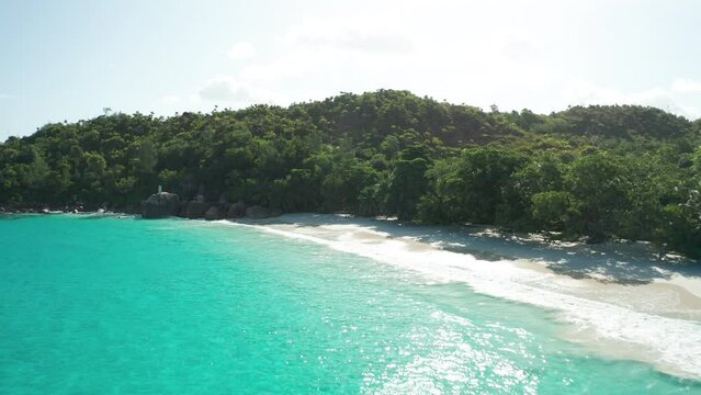 Aerial dolly over emerald water and yacht to Anse Lazio beach, Praslin