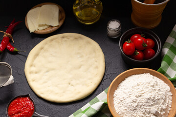 Pizza and dough homemade cooking with ingredients on table. Pizza with sauce at tabletop