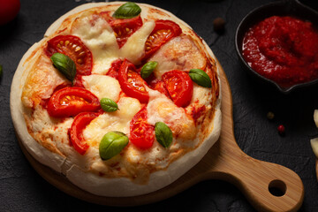 Pizza and sauce homemade cooking with ingredients on table. Pizza at tabletop