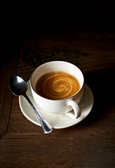 Cup of coffee on dark wooden table