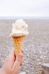ice cream in hand on a beach background