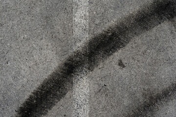 Asphalt texture with white line and tire marks. Smooth asphalt road. Tarmac dark grey grainy road background.Top view - 502098230