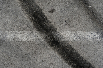 Asphalt texture with white line and tire marks. Smooth asphalt road. Tarmac dark grey grainy road background.Top view - 502098272