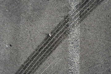 Asphalt texture with white line and tire marks. Smooth asphalt road. Tarmac dark grey grainy road background.Top view - 502098491