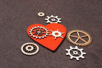 Gear wheels on red Heart shape. Valentine concept and promise of love.