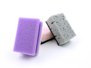 Colored dishwashing sponges on white background. Sponges for washing dishes and other domestic needs. Grey and purple sponge at a slight angle