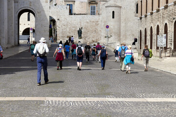 Turisti in cammino verso la Basilica di San Nicola. Bari, sud Italia