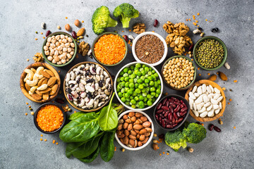 Vegan protein source. Legumes, beans, lentils, nuts, broccoli, spinach and seeds. Top view on stone table. Healthy vegetarian food. - obrazy, fototapety, plakaty