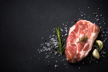 Fresh steak with rosemary and spices at black background. Top view with copy space.