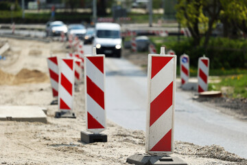 Słupki ostrzegawcze na budowie nowej drogi w mieście.  - obrazy, fototapety, plakaty