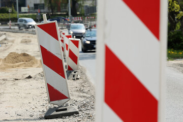 Słupki ostrzegawcze na budowie nowej drogi w mieście.  - obrazy, fototapety, plakaty