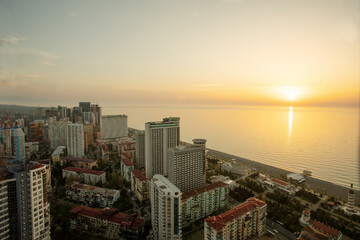 Fototapeta na wymiar Black sea coast in Batmu - idyllic view from skyscraper to water and high and low building - sunset!