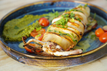 Grilled calamari with pesto sauce served in seafood restaurant