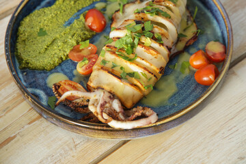 Grilled calamari with pesto sauce served in seafood restaurant