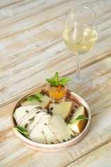 Summer melon cheese plate with glass of white wine