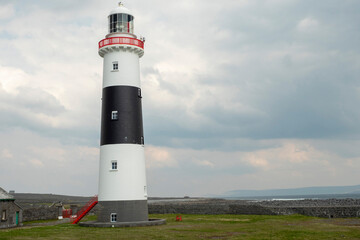 Inisheer lighthouse, Aran island, county Galway, Ireland. Popular travel and tourism area. Irish landscape. Nobody. Blue cloudy sky.