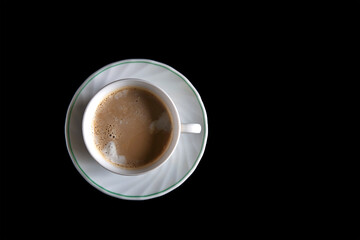 Top view of a cup of coffee isolated on black background. Top view with copy space switch concept. Get energy in the morning. Caffeine stimulates the brain.