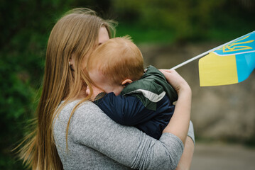 Child crying and calls to Stop war in Ukraine. Family and people raises yellow and blue flag...