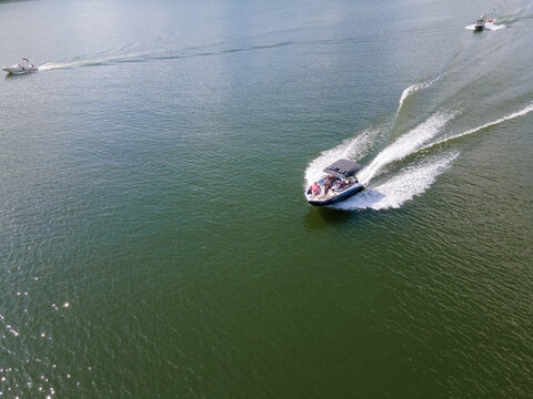 Ski Boats At Full Throttle On An Empty Lake. Large Wake Waves Behind Speed Boats.