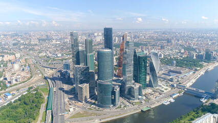 Fototapeta na wymiar Top view of business center with skyscrapers on background of panorama of city. Action. Cityscape with breathtaking views of mirrored skyscrapers on background blue sky and river