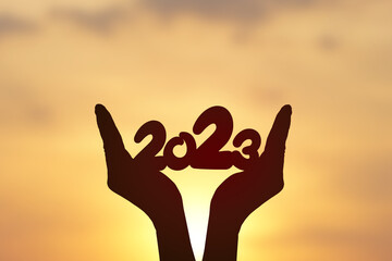 2023 silhouette on human hand. Happy new year concept.