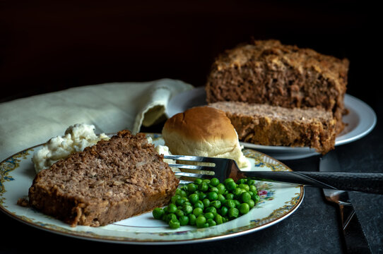 Home made meatloaf dinner with peas, mashed potaoes and a dinner roll
