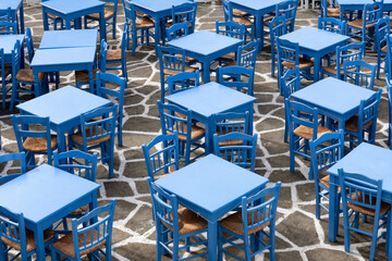 Blue tables and chairs of a taverna - obrazy, fototapety, plakaty