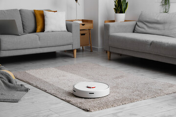 Modern robot vacuum cleaner on soft carpet in room - obrazy, fototapety, plakaty