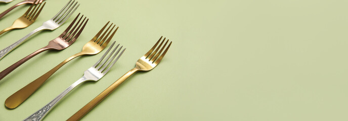 Many different forks on green background with space for text