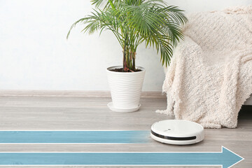 Modern robot vacuum cleaner on wooden floor near sofa in room