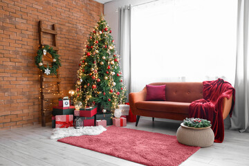 Christmas tree with presents and comfortable sofa with red carpet in interior of living room