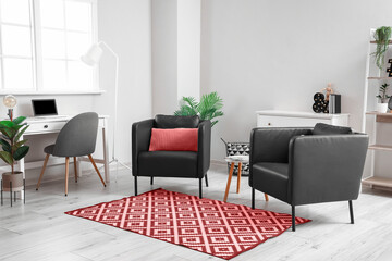 Interior of modern living room with black armchairs and red carpet