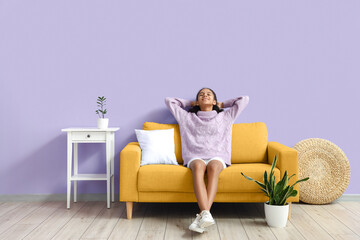 African-American teenage girl relaxing on sofa in room