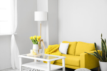 Interior of modern living room with yellow sofa and Easter decor