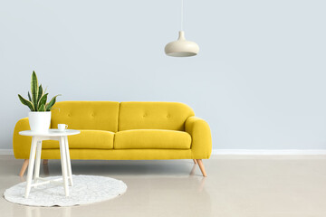 Comfortable yellow sofa and table in interior of living room