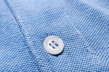 Closeup view of button on stylish blue shirt