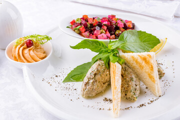 forshmak of herring with croutons and vinigret on a white plate macro close up