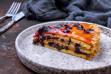Blueberry pie on a grey plate on dark stone table