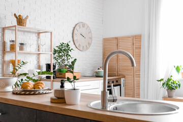 Big clock hanging on white brick wall in kitchen