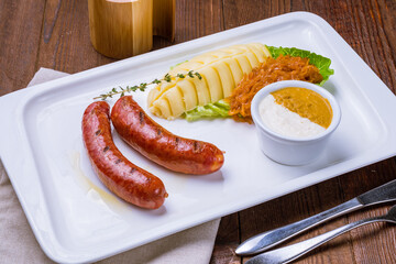 Tyrolean sausages with potatoes and fried cabbage on plate
