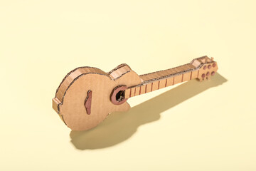 Cardboard guitar toy on beige background
