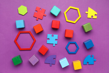 Fototapeta na wymiar Colorful cubes with blocks and puzzle pieces on purple background