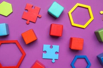 Colorful cubes with blocks and puzzle pieces on purple background