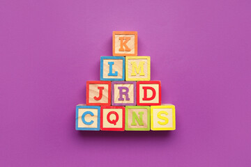 Wooden cubes with letters on purple background