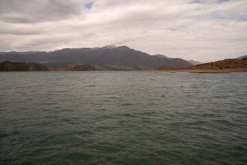 View of the reservoir in Potrerillos, Mendoza. The arid environment, turquoise glacier water lake and Andes mountains in the background.