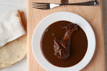Chicken with mole, Mexican tradition, placed on wood