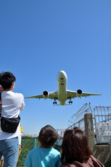 飛行機の着陸を見上げる親子