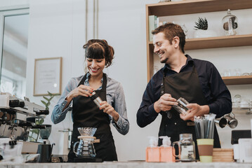 Couple barista working in coffee shop. Happy coffee owner standing behind the counter of a coffee cafe.