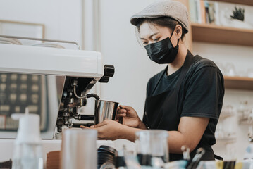 Asian woman Barista using coffee machine in coffee shop. female barista wearing medical face mask working in coffee cafe.