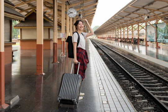 Asian woman backpacker traveler plan summer holiday after coronavirus. Empty tourists on train railway platforms. Use bus train sustainable environmental friendly transport